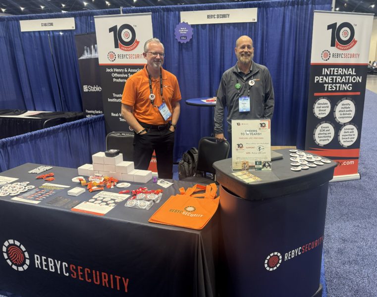 Patrick Barry and Chris Horner at the Rebyc Booth, with our Internal Penetration Testing banner